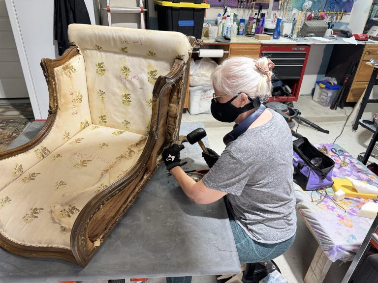 Woman working on stripping a chair