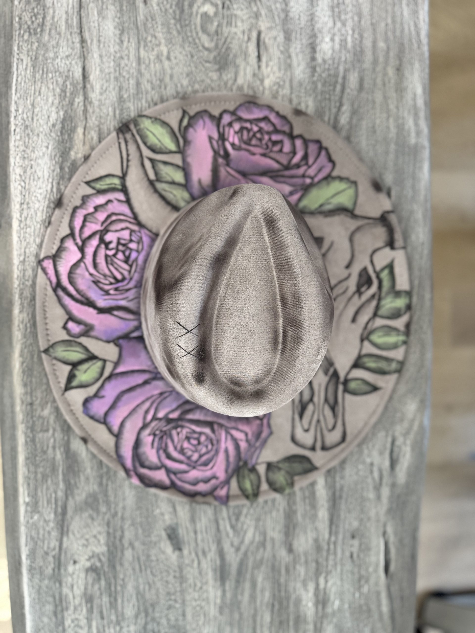 hand burned wide brim hat featuring cow skull with horns and hand painted pink and purple roses.