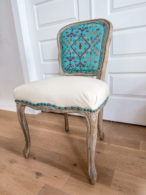 Accent chair with southwestern turquoise textile back and cream leather seat.
