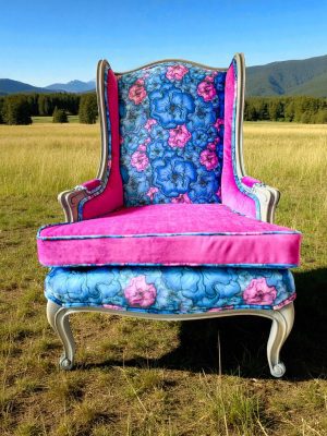 front view of electric blue acid wash cowhide wingback chair; features velvet floral pattern and a reversible cushion in fushia.